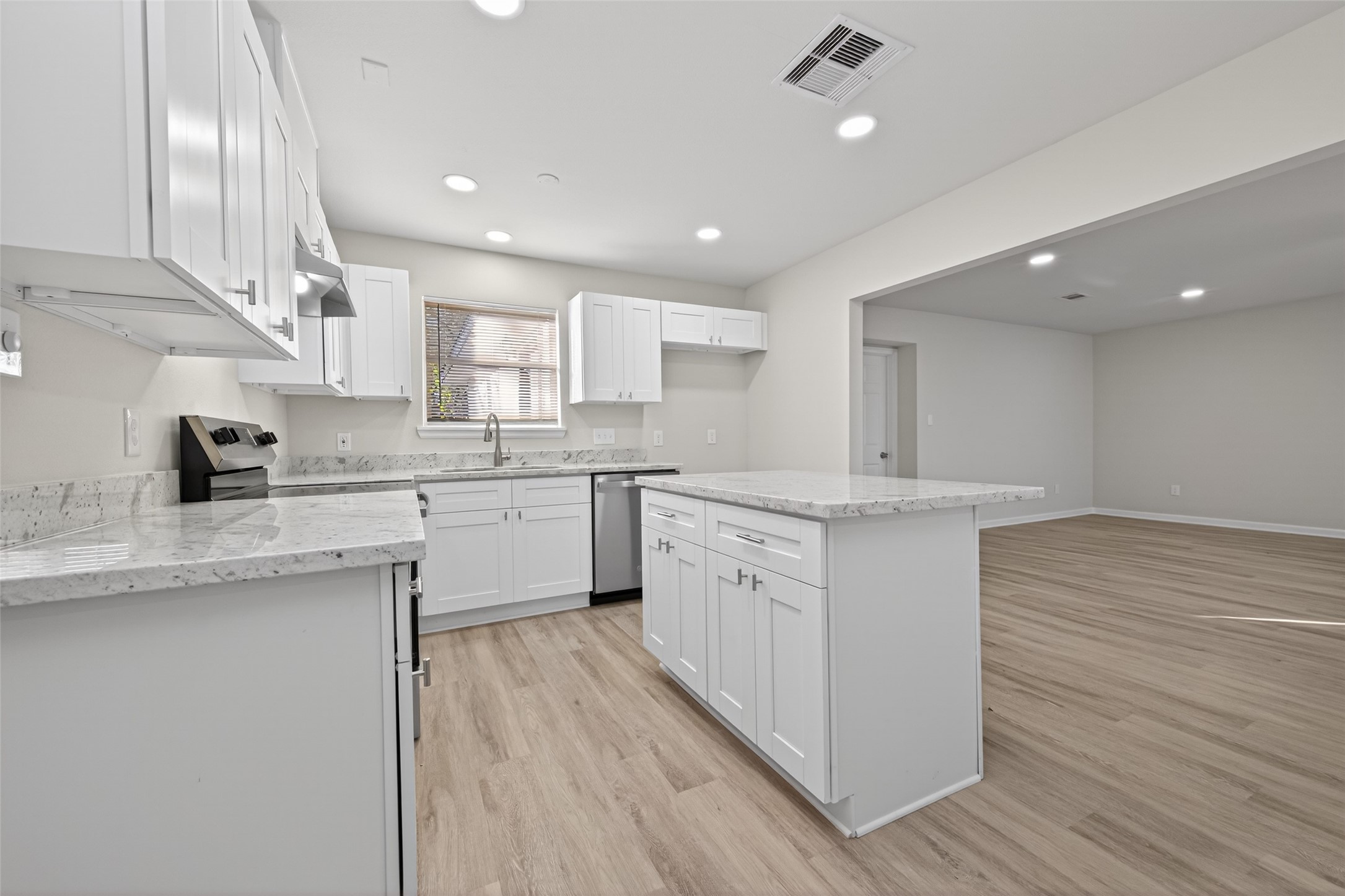1238 Hopper Road Houston, TX 77037 - Photo 9 of 40 a kitchen with stainless steel appliances granite countertop a sink a stove a refrigerator and island with wooden floor