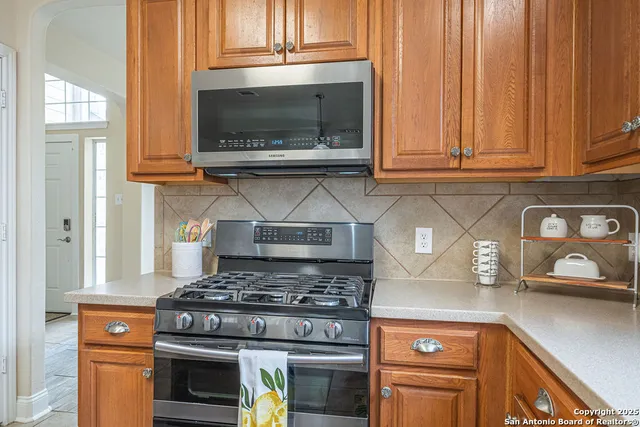 a kitchen with stainless steel appliances granite countertop a stove and a microwave