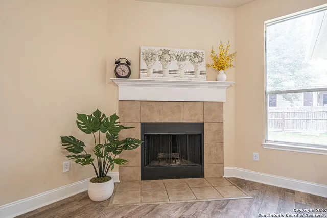 a living room with a fireplace and potted plant