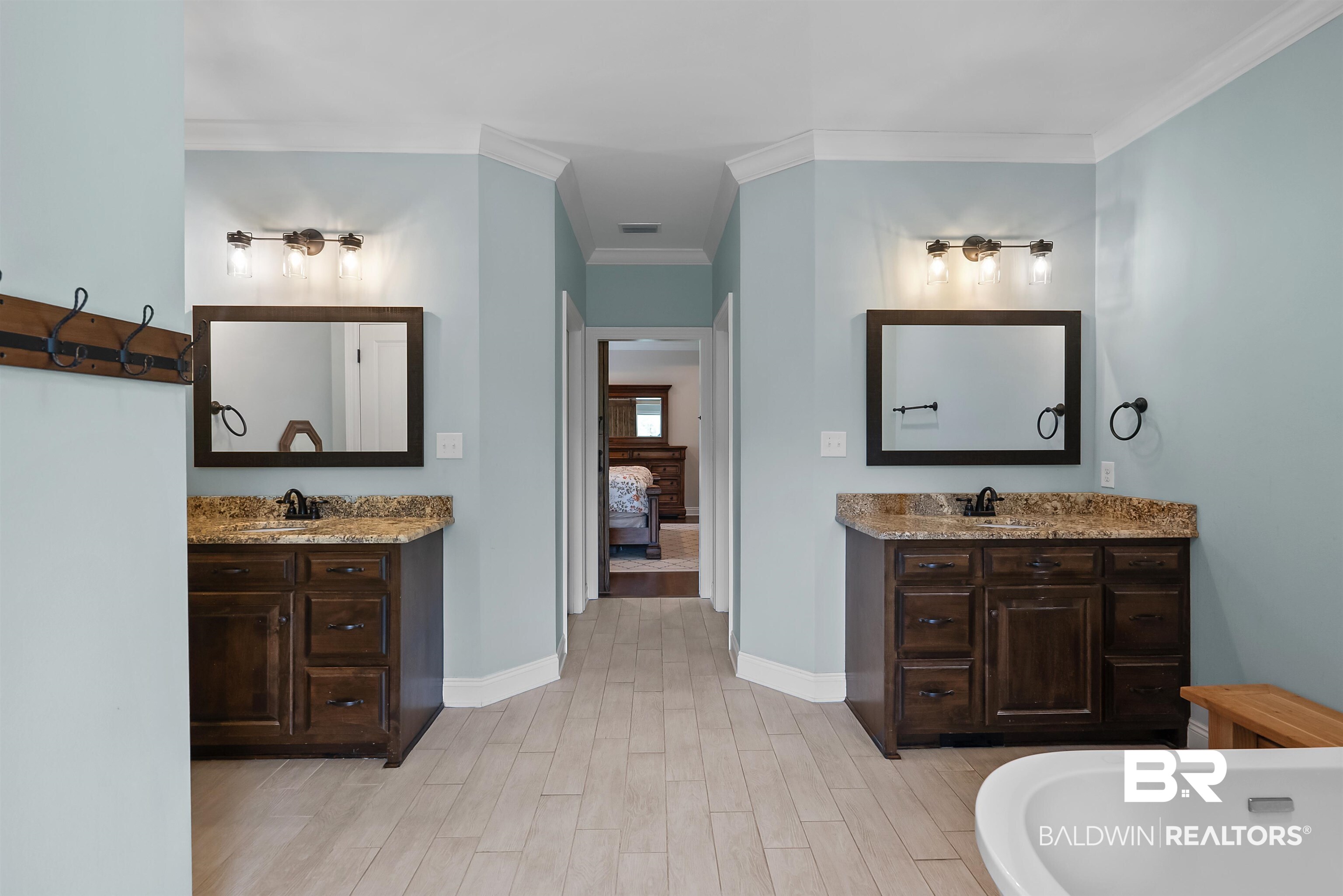 12070 Comalander Road Fairhope, AL 36532 - Photo 22 of 50 Bathroom featuring two dark wood vanities with stone countertops, individual framed mirrors, and industrial-style vanity lighting