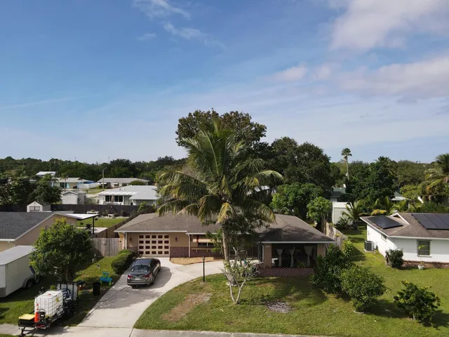 an aerial view of a house with garden space and street view