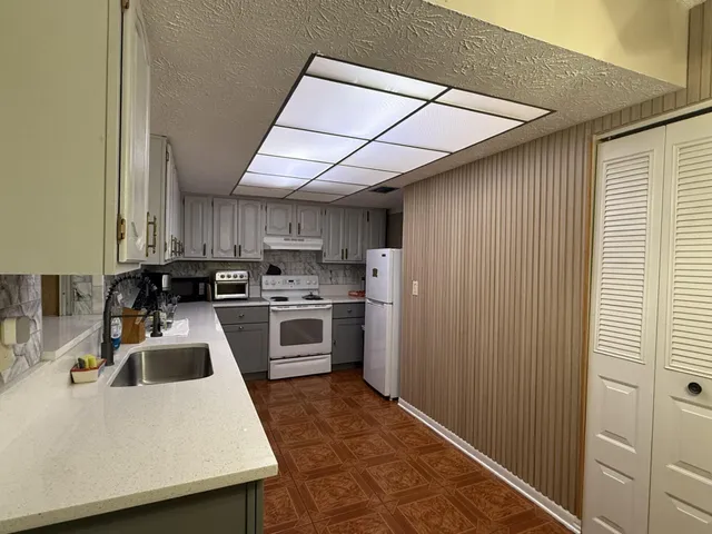 a kitchen with a sink a stove and refrigerator