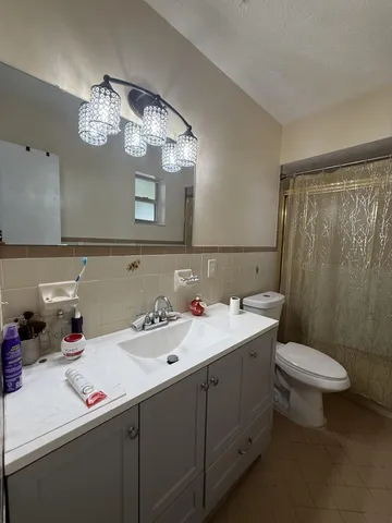 a bathroom with a sink a toilet and a mirror