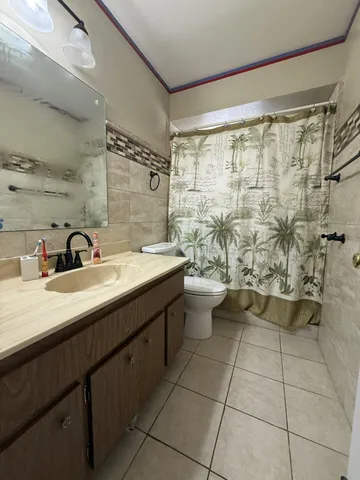 a bathroom with a double vanity sink toilet and shower
