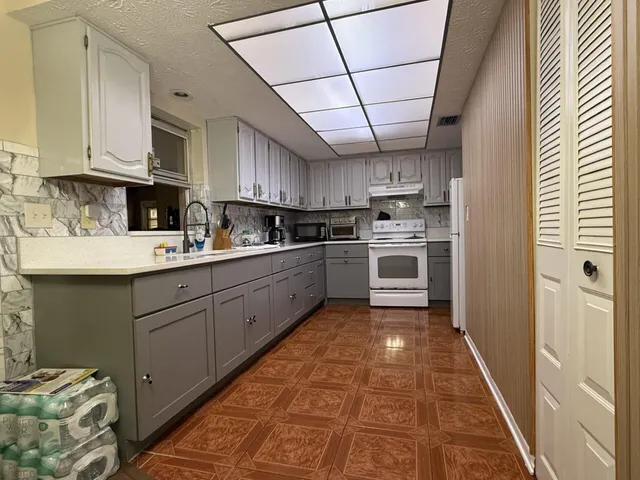 a kitchen with cabinets wooden floor and stainless steel appliances