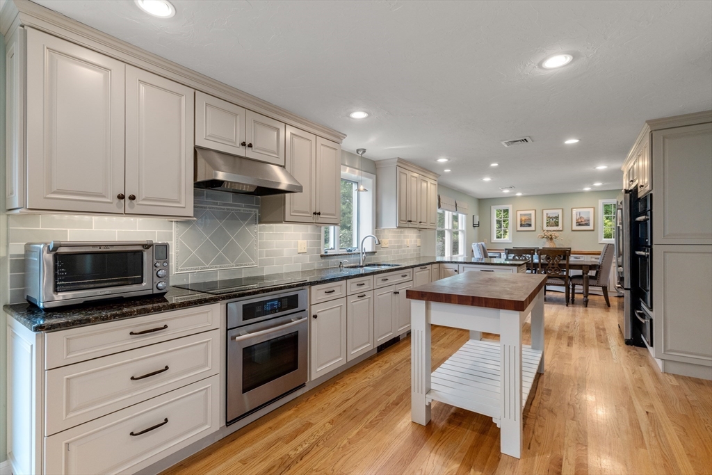 322 Concord Road Wayland, MA 01778 - Photo 2 of 35 a kitchen with stainless steel appliances kitchen island granite countertop a stove a sink and a microwave