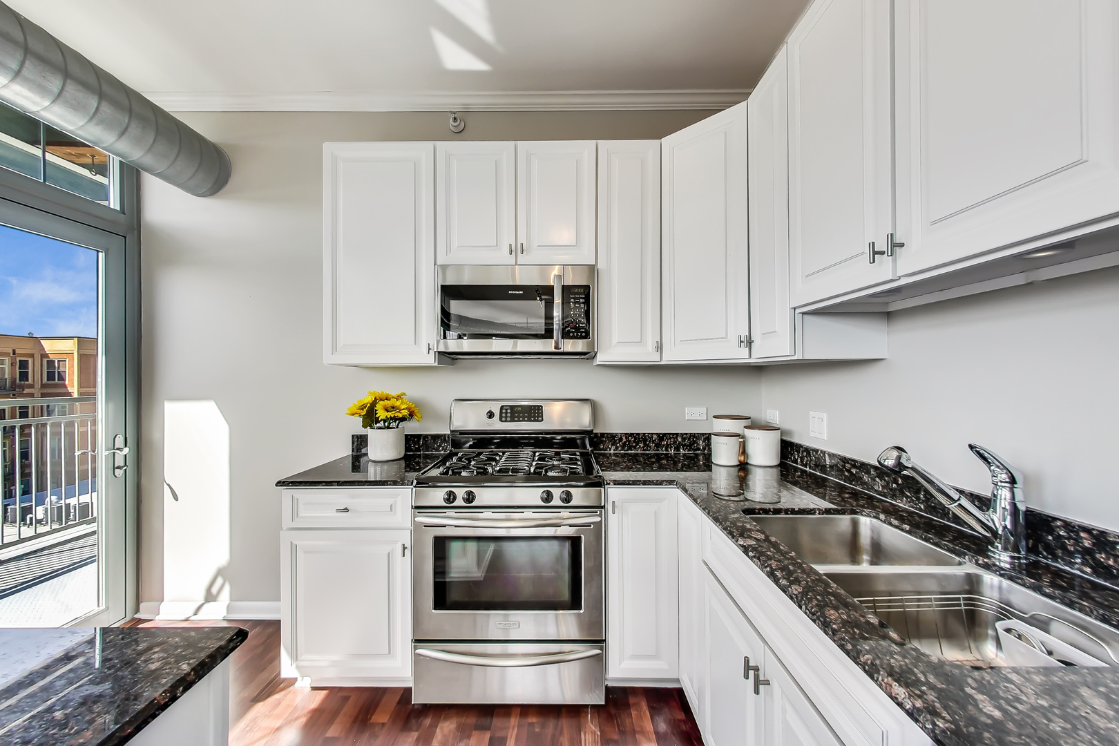 1200 West Monroe Street, Unit 511 Chicago, IL 60607 - Photo 5 of 12 a kitchen with granite countertop a sink a stove and cabinets