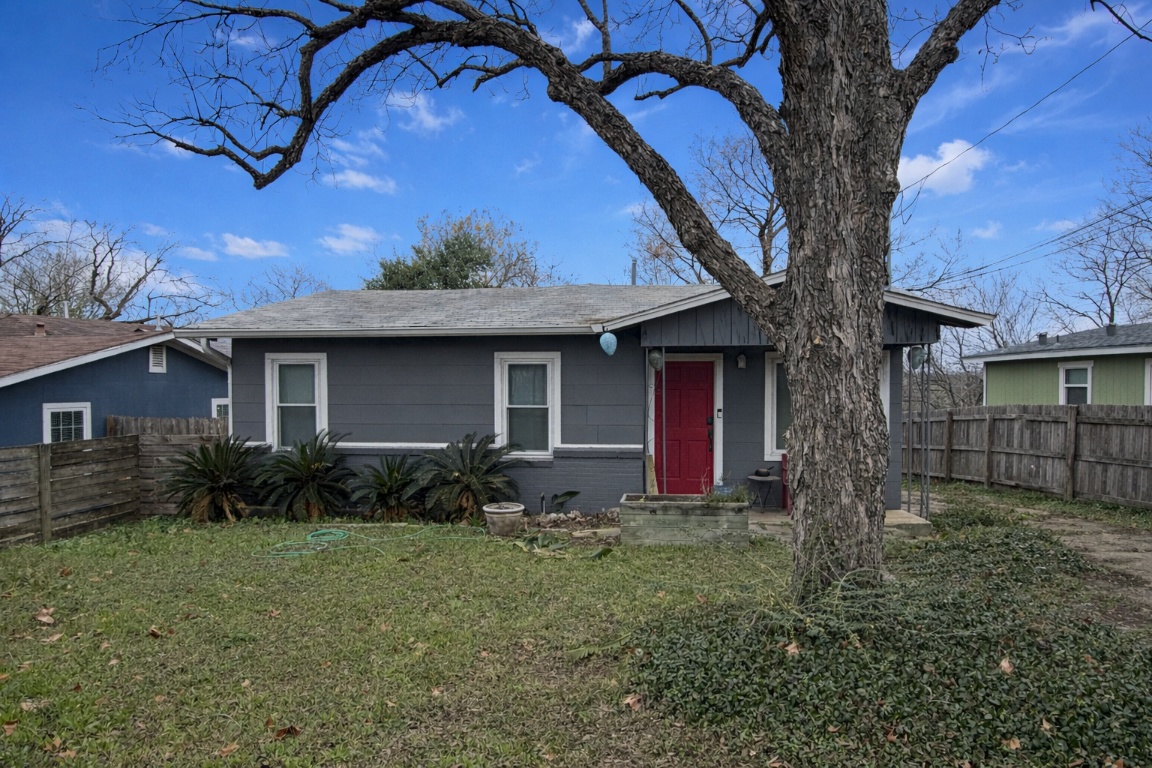 a view of house with a yard and a large tree