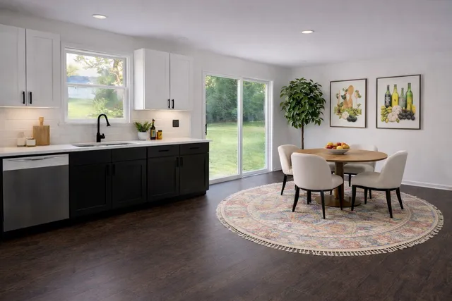 a dining room with furniture a large window and wooden floor