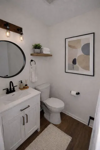 a bathroom with a toilet sink and mirror