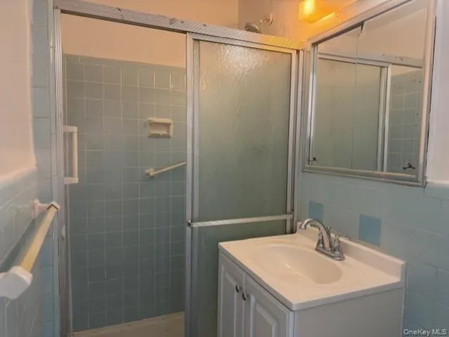 a bathroom with a sink mirror and shower