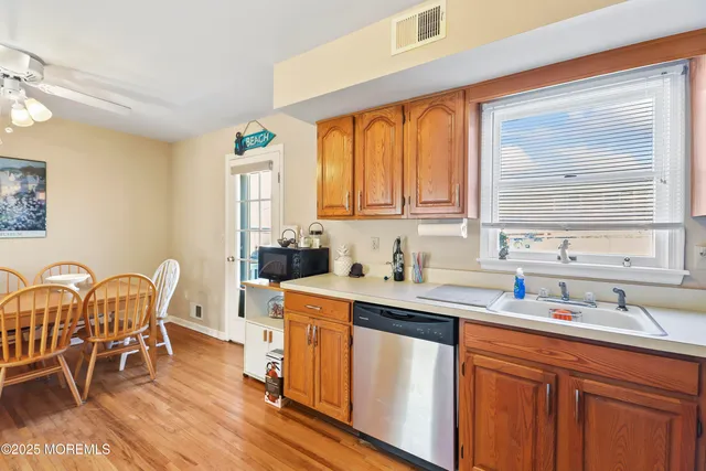 a kitchen with stainless steel appliances granite countertop a table chairs sink and cabinets