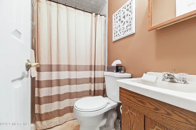 a bathroom with a sink a toilet and shower curtain