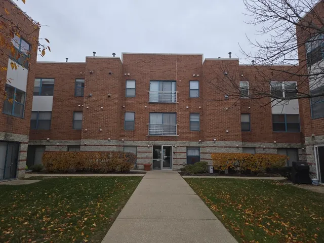 a view of a brick building next to a yard