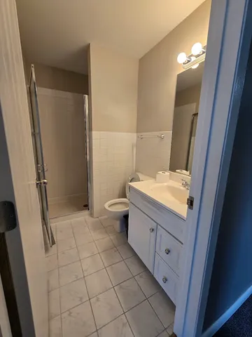 an empty room with a chandelier fan and a large mirror