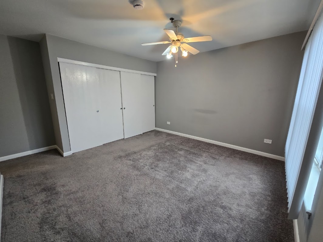 3255 Kirchoff Road, Unit 301 Rolling Meadows, IL 60008 - Photo 15 of 24 an empty room with a chandelier fan and a large mirror