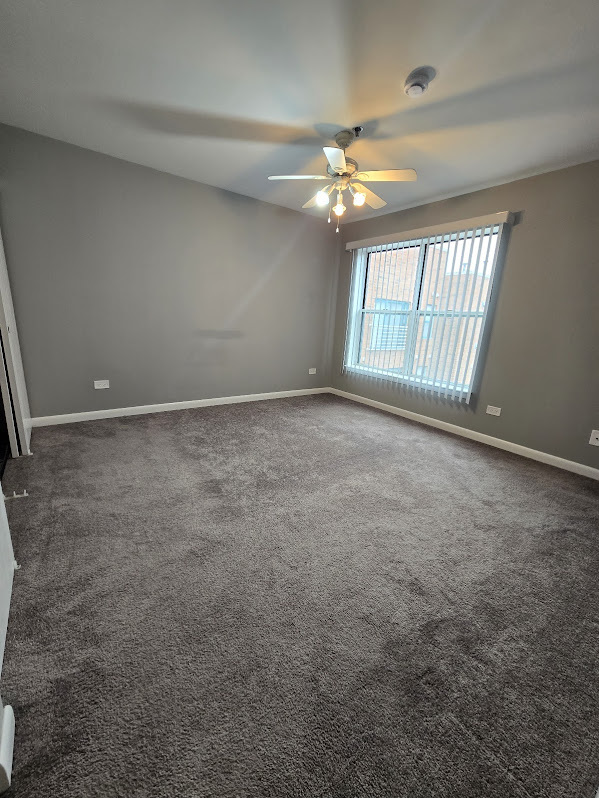 3255 Kirchoff Road, Unit 301 Rolling Meadows, IL 60008 - Photo 16 of 24 an empty room with chandelier fan and windows