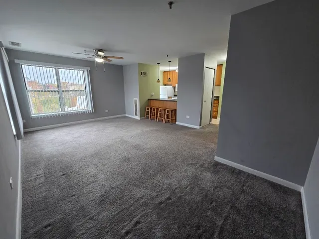 an empty room with windows and cabinet