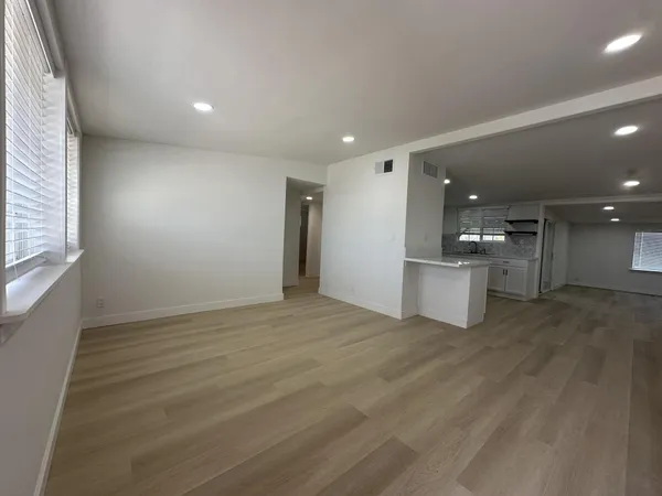 a view of empty room with wooden floor and windows