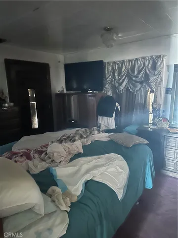 a bedroom with a bed and painting on the wall