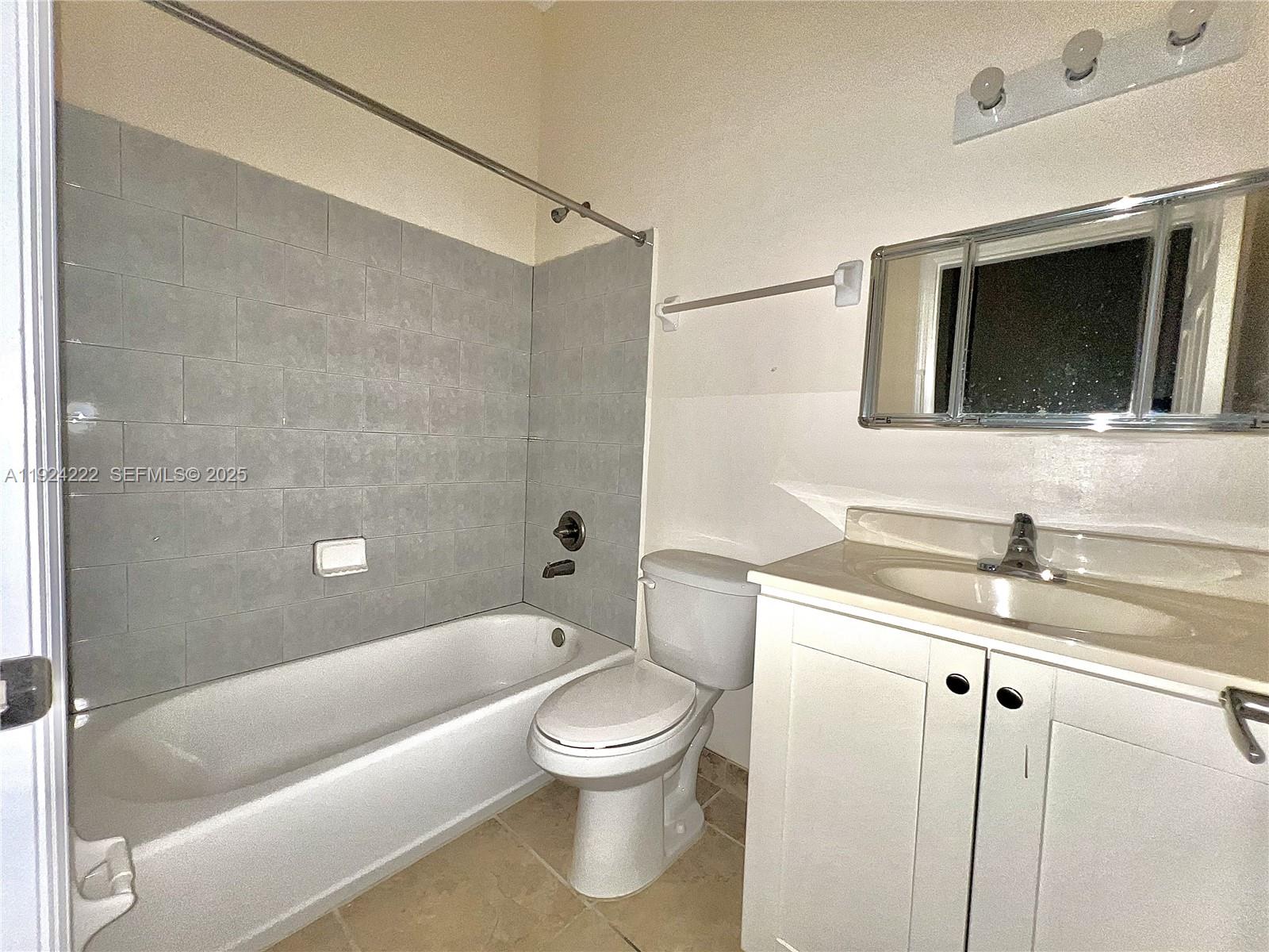1253 Southwest 2nd Street, Unit 209 Miami, FL 33135 - Photo 3 of 11 a bathroom with a granite countertop toilet a sink and bathtub