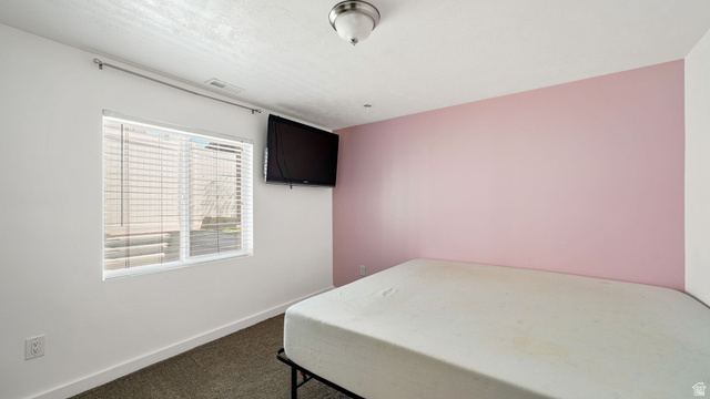 6062 Spring Street Stansbury Park, UT 84074 - Photo 20 of 36 Room featuring a neutral ceiling, light pink accent wall, and white painted walls