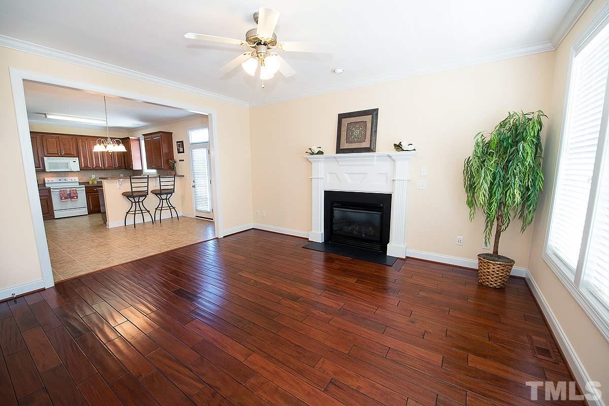 5005 Contender Drive Raleigh, NC 27603 - Photo 4 of 21 a view of an empty room with a fireplace and wooden floor