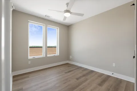 a view of an empty room with wooden floor