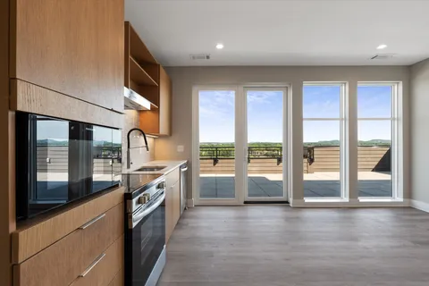 a kitchen with stainless steel appliances granite countertop a stove and a large window