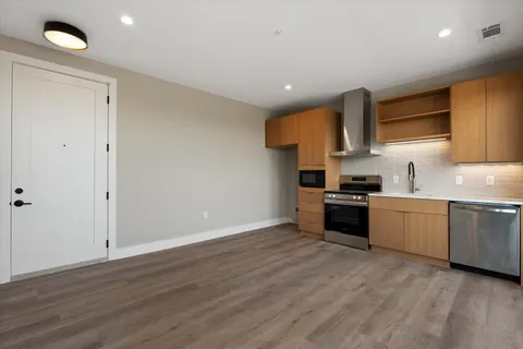 a kitchen with granite countertop a sink cabinets and stainless steel appliances