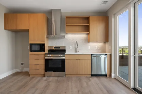 a kitchen with stainless steel appliances granite countertop a stove a sink and a refrigerator