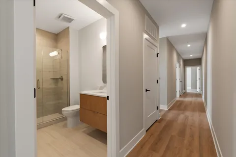 a spacious bathroom with a granite countertop toilet a sink and a mirror