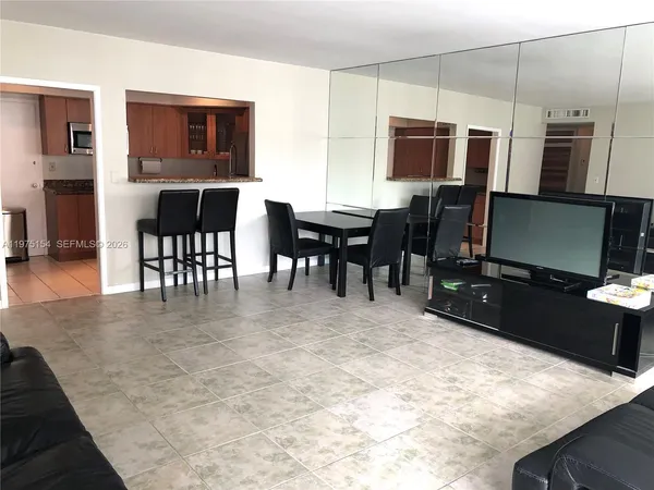 a kitchen with a table chairs refrigerator and microwave