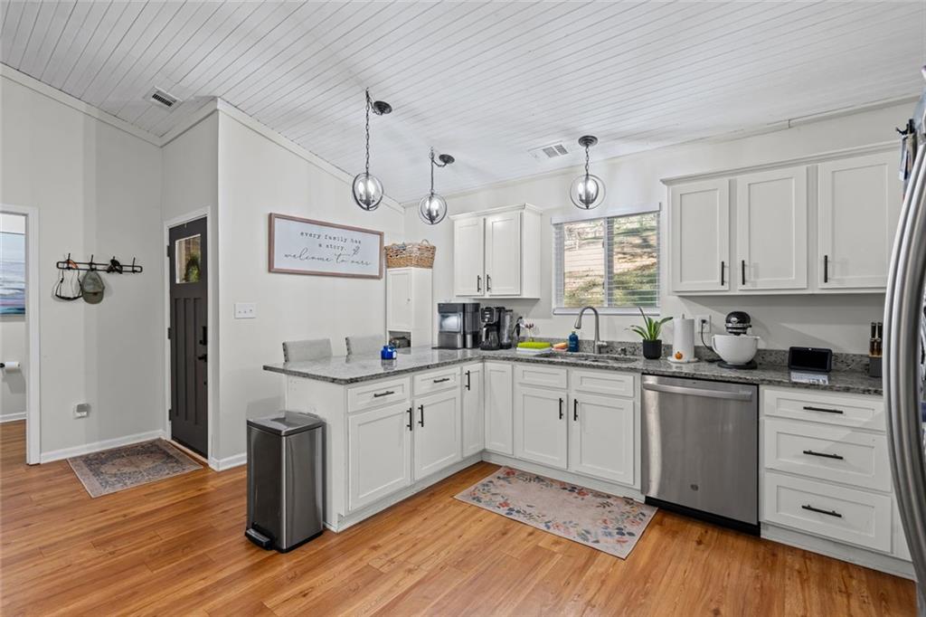 3675 Rosedale Circle Gainesville, GA 30506 - Photo 11 of 32 a kitchen with stainless steel appliances granite countertop a sink cabinets and wooden floor