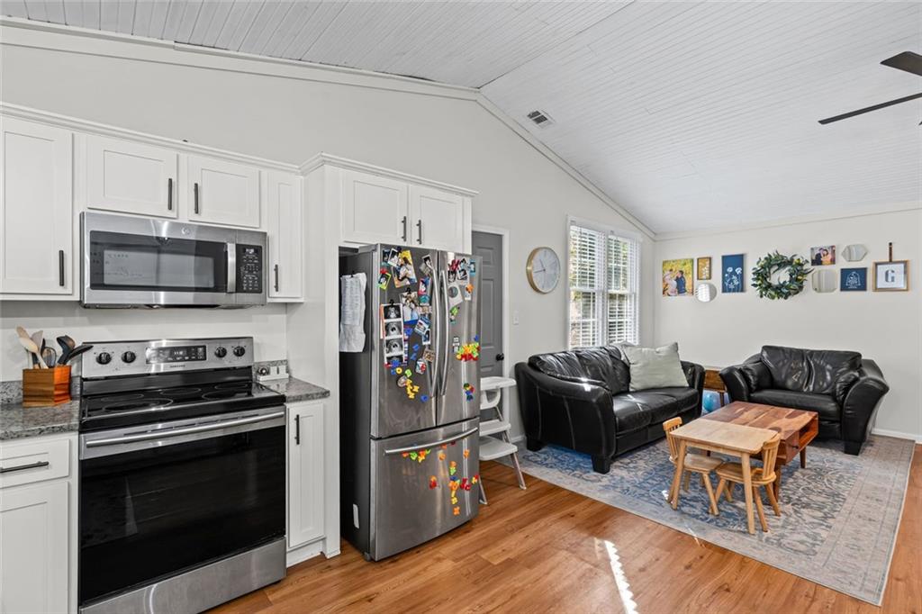 3675 Rosedale Circle Gainesville, GA 30506 - Photo 13 of 32 a living room with furniture a flat screen tv and a refrigerator