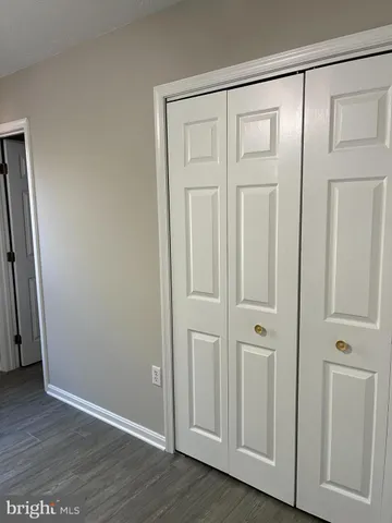 an empty room with wooden floor and closet area