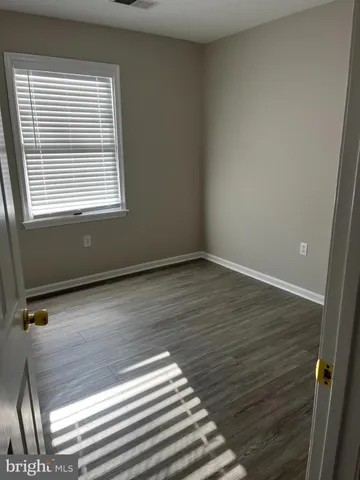 a view of a room with wooden floor and a window