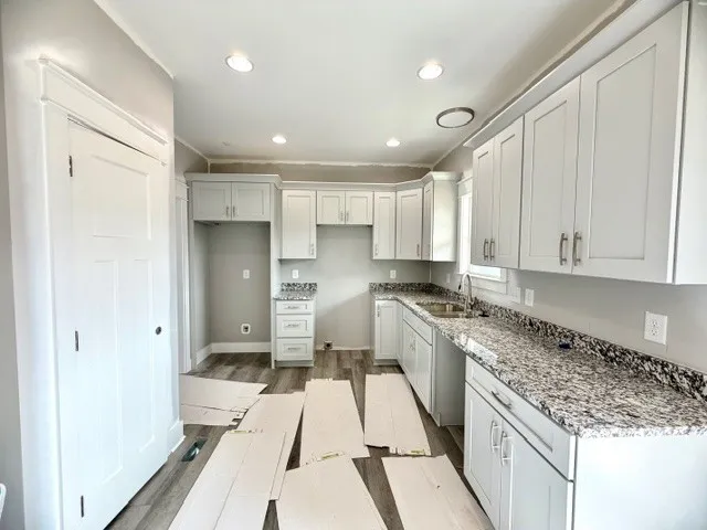 a kitchen with stainless steel appliances granite countertop a refrigerator and a sink