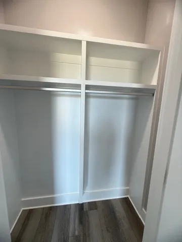 a view of walk in closet with wooden floor