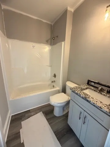 a bathroom with a granite countertop toilet a sink and bathtub