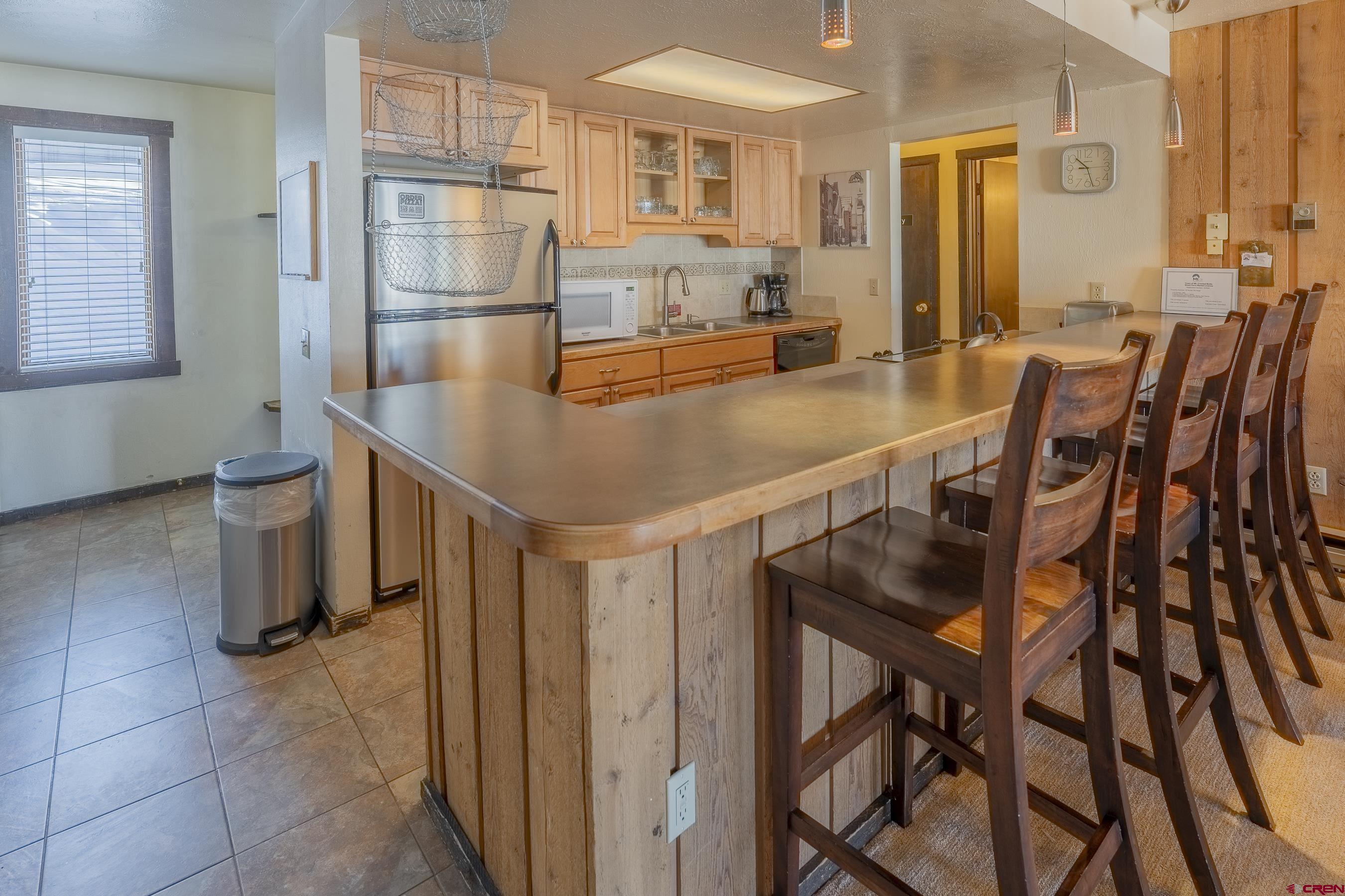 18 Hunter Hill Road, Unit J304 Crested Butte, CO 81225 - Photo 12 of 40 a kitchen with stainless steel appliances a table and chairs