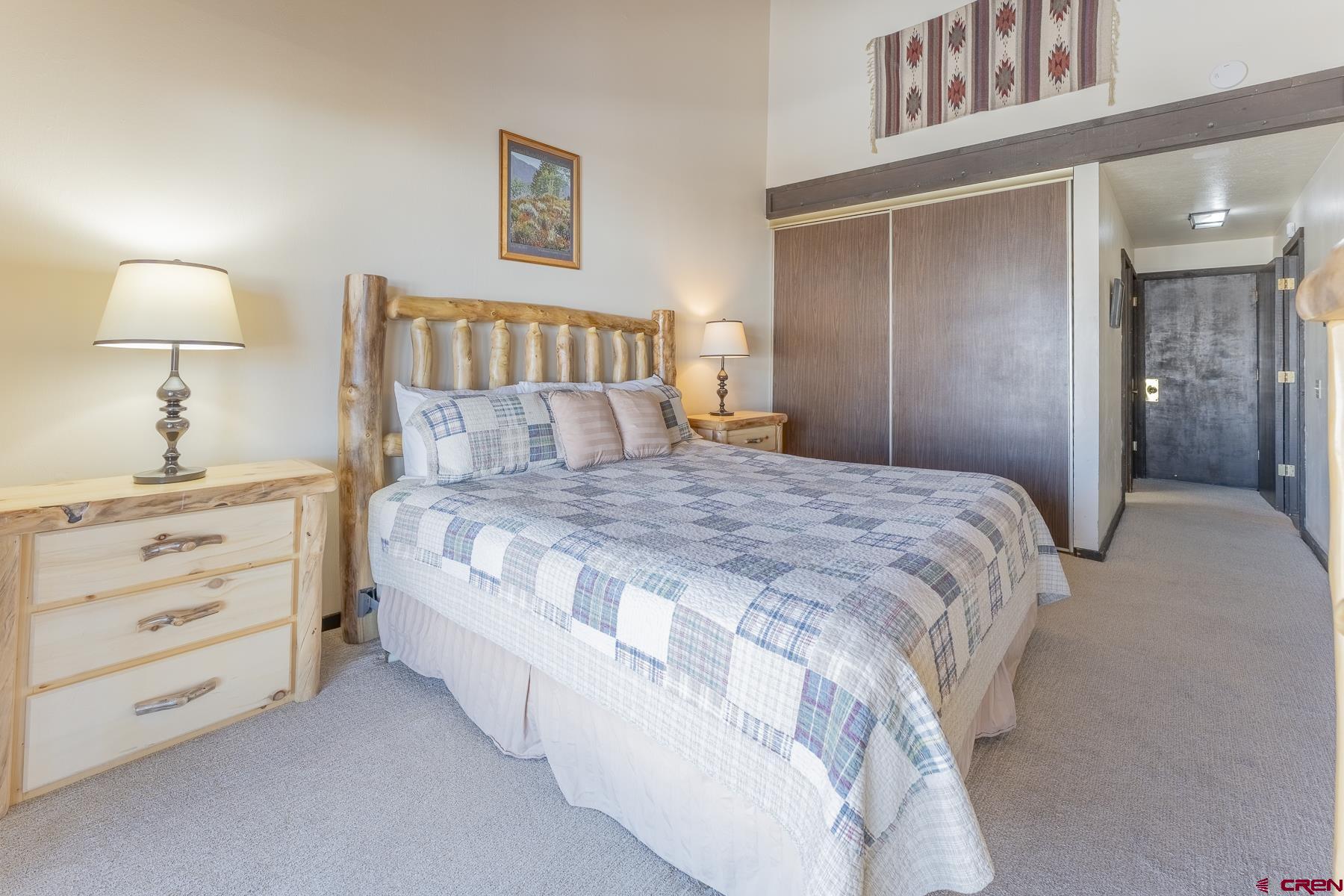 18 Hunter Hill Road, Unit J304 Crested Butte, CO 81225 - Photo 14 of 40 a bedroom with a bed and a lamp on dresser