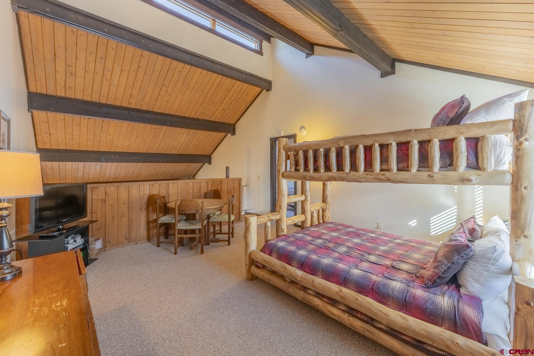 18 Hunter Hill Road, Unit J304 Crested Butte, CO 81225 - Photo 23 of 40 a bedroom with a bed and a table in it