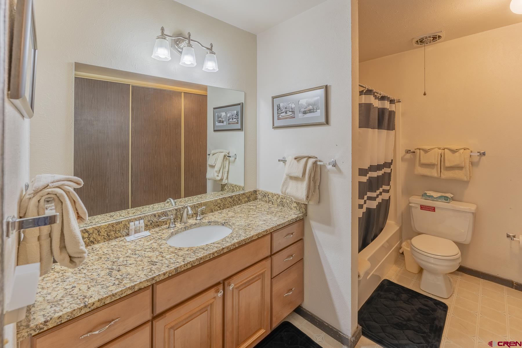 18 Hunter Hill Road, Unit J304 Crested Butte, CO 81225 - Photo 26 of 40 a bathroom with a granite countertop sink a mirror and a toilet