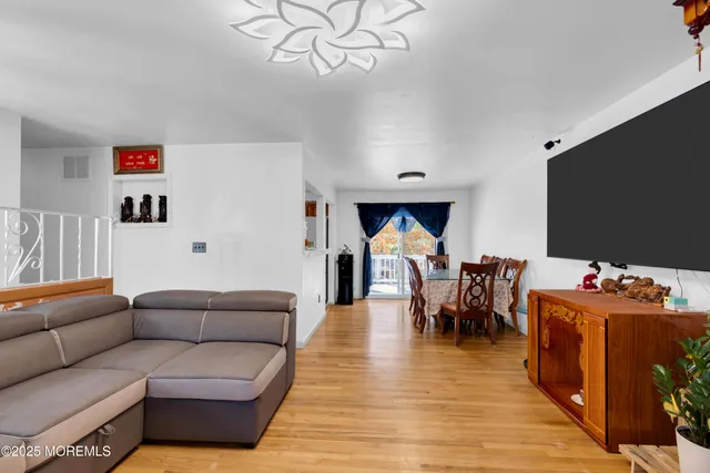 a living room with furniture kitchen view and a flat screen tv