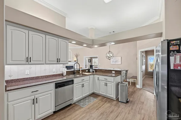 a kitchen with a sink cabinets and wooden floor