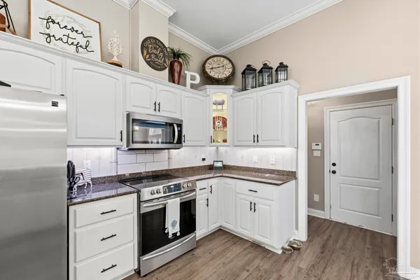 a kitchen with cabinets stainless steel appliances and wooden floor