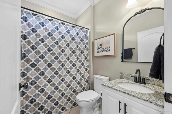 a bathroom with a granite countertop toilet sink and mirror