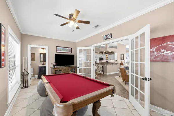 a room with pool table and windows