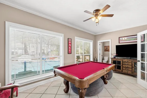 a room with pool table flat screen tv and windows